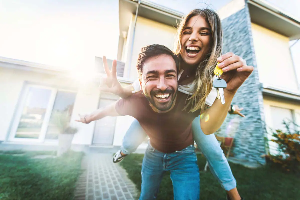 Couple celebrating outside their new home