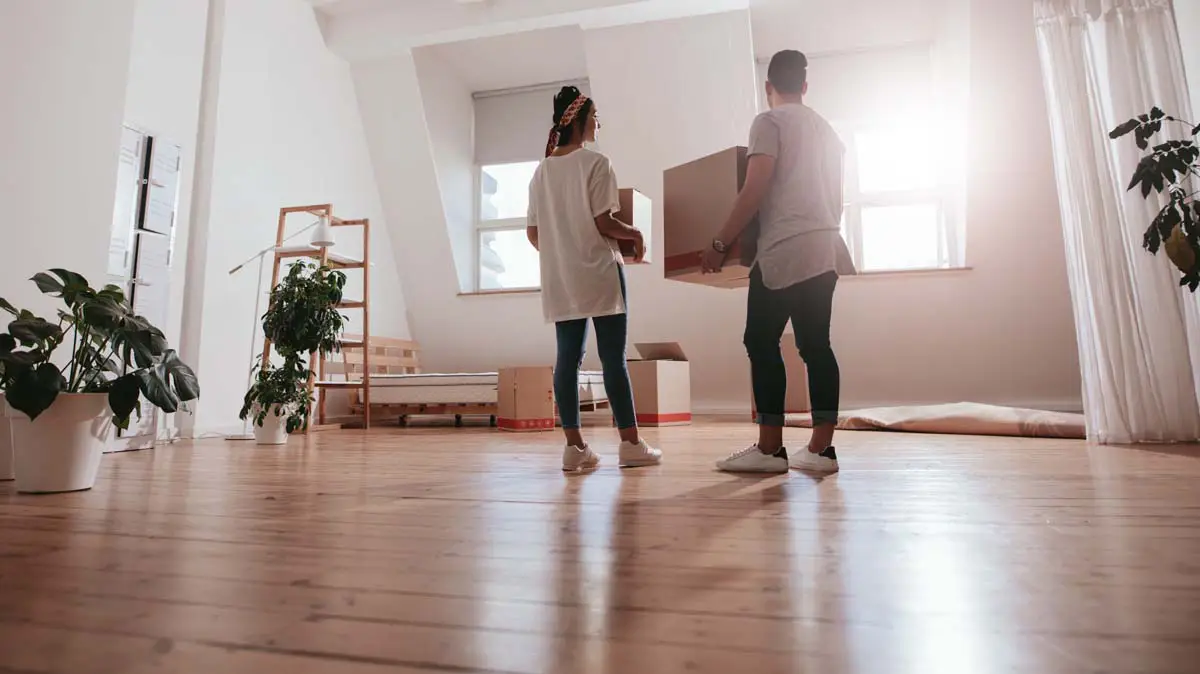 Couple with a moving box, ready for homeownership questions