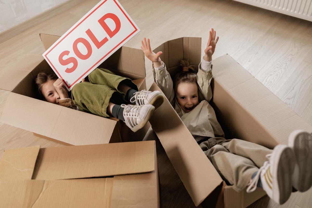 Sold sign and moving boxes at a new home
